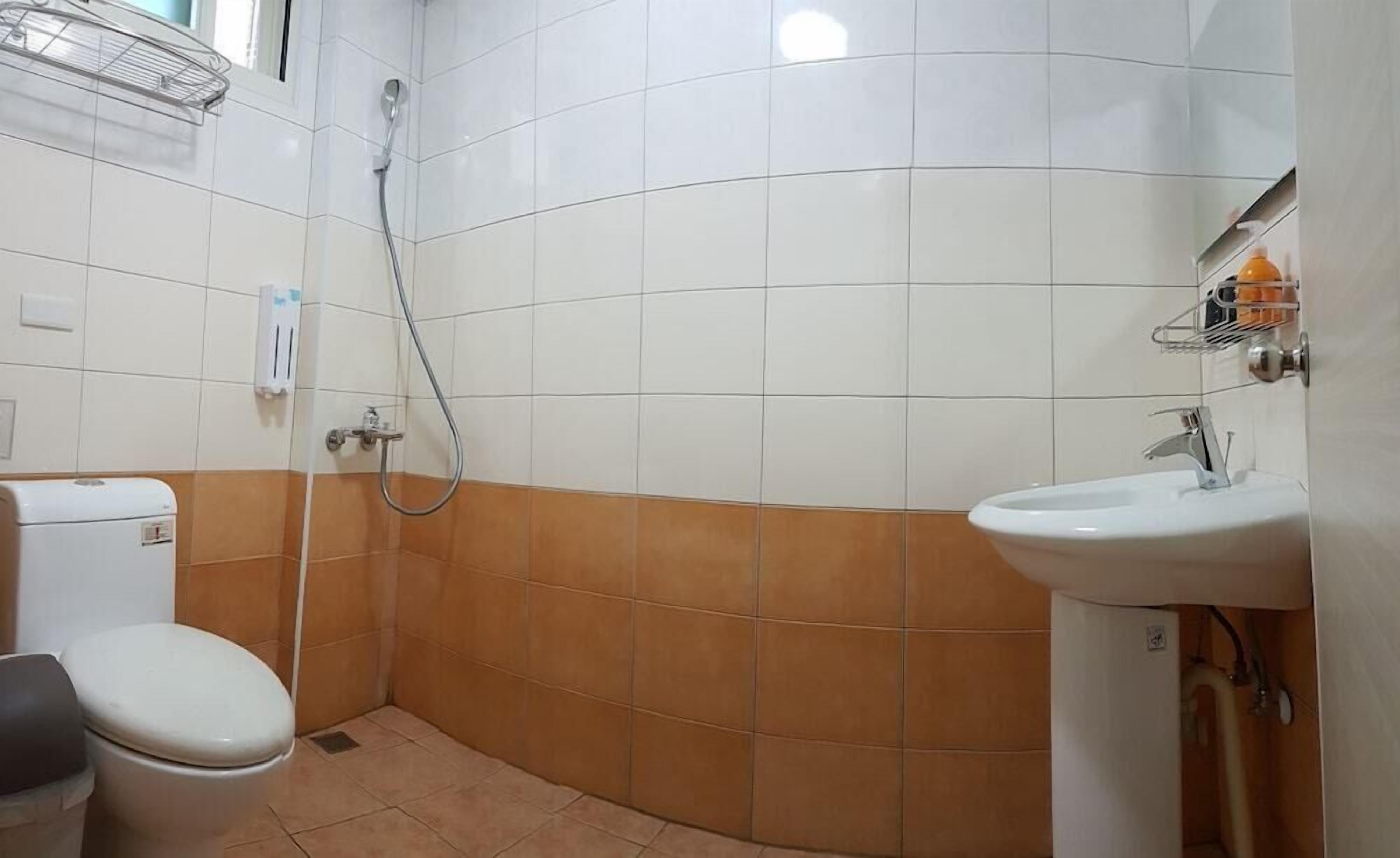 Een badkamer met toilet, douche en wastafel.