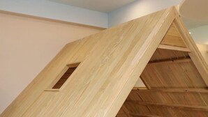 A wooden structure with a triangular roof and a small window, likely a part of a building's interior. - Happiness YES (Yilan)
