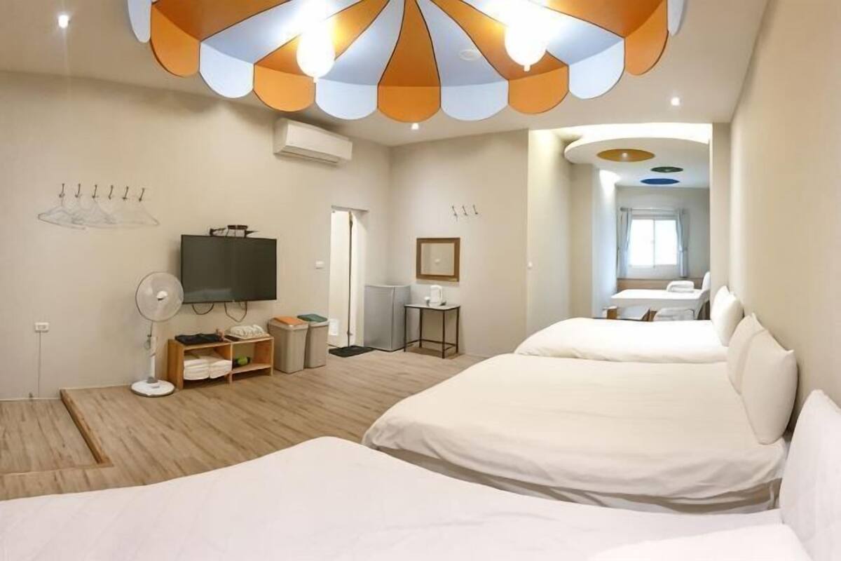 Hotellihuone, jossa on kaksi sänkyä, televisio, työpöytä ja kylpyhuone.