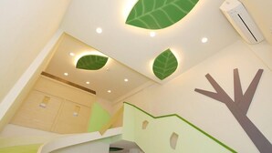 A children's play area with a slide, a climbing wall, and a wall-mounted air conditioning unit. - Happiness YES (Yilan)