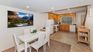 A modern kitchen with wooden cabinets, a white refrigerator, and a window with blinds. - Snowy Pines | Walk to Snow Summit · Fireplace (Big Bear Lake)
