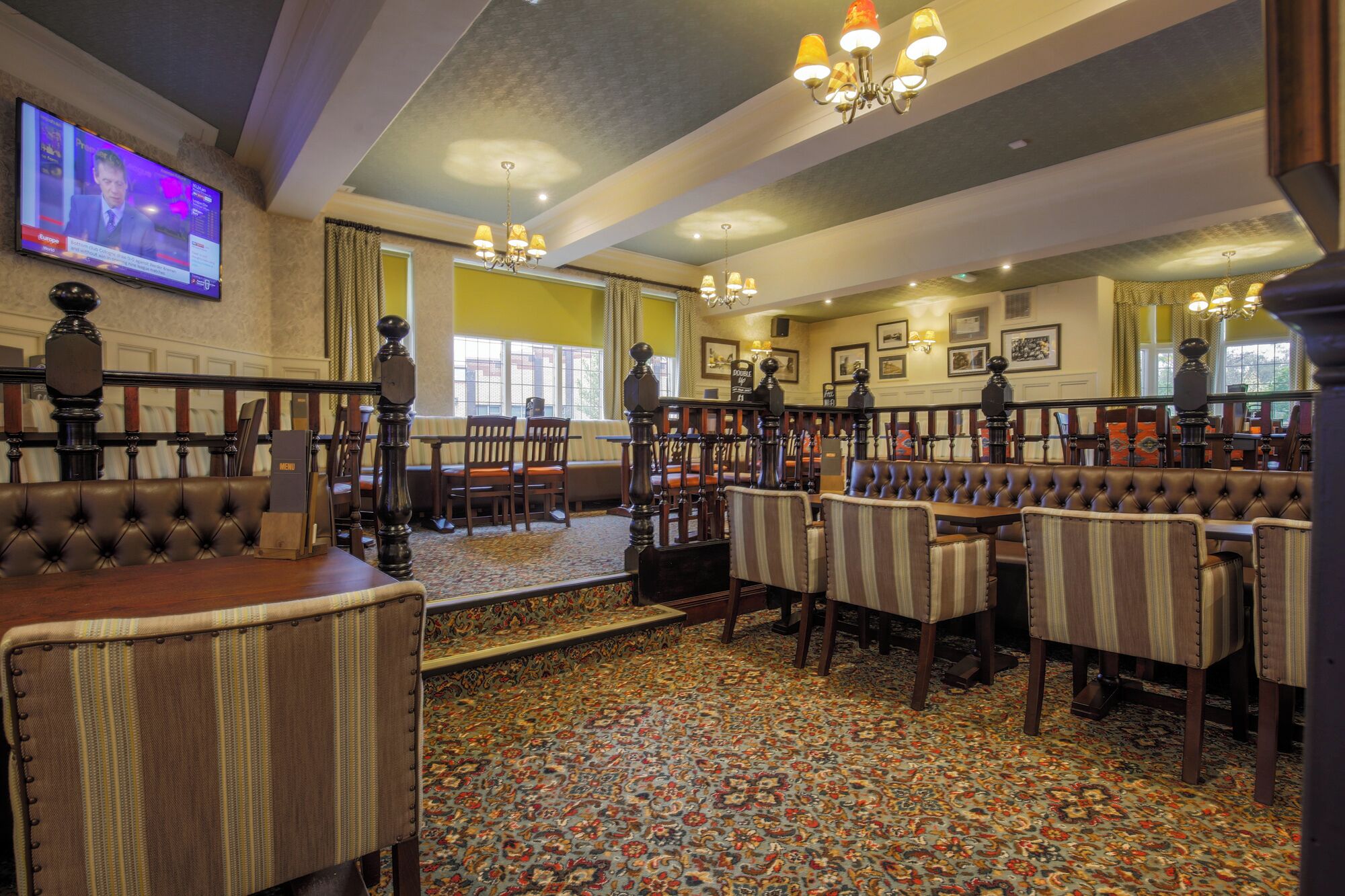 A restaurant with high-backed booths, striped chairs, and a patterned carpet.