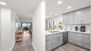 A modern kitchen with grey cabinets, a stainless steel sink, and a coffee maker.
