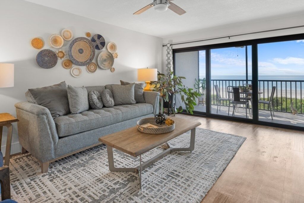 A modern living room with a grey sofa, wooden coffee table, and decorative wall art.