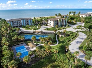 Ein Resort mit mehreren Gebäuden, einem Poolbereich und Blick auf den Ozean.