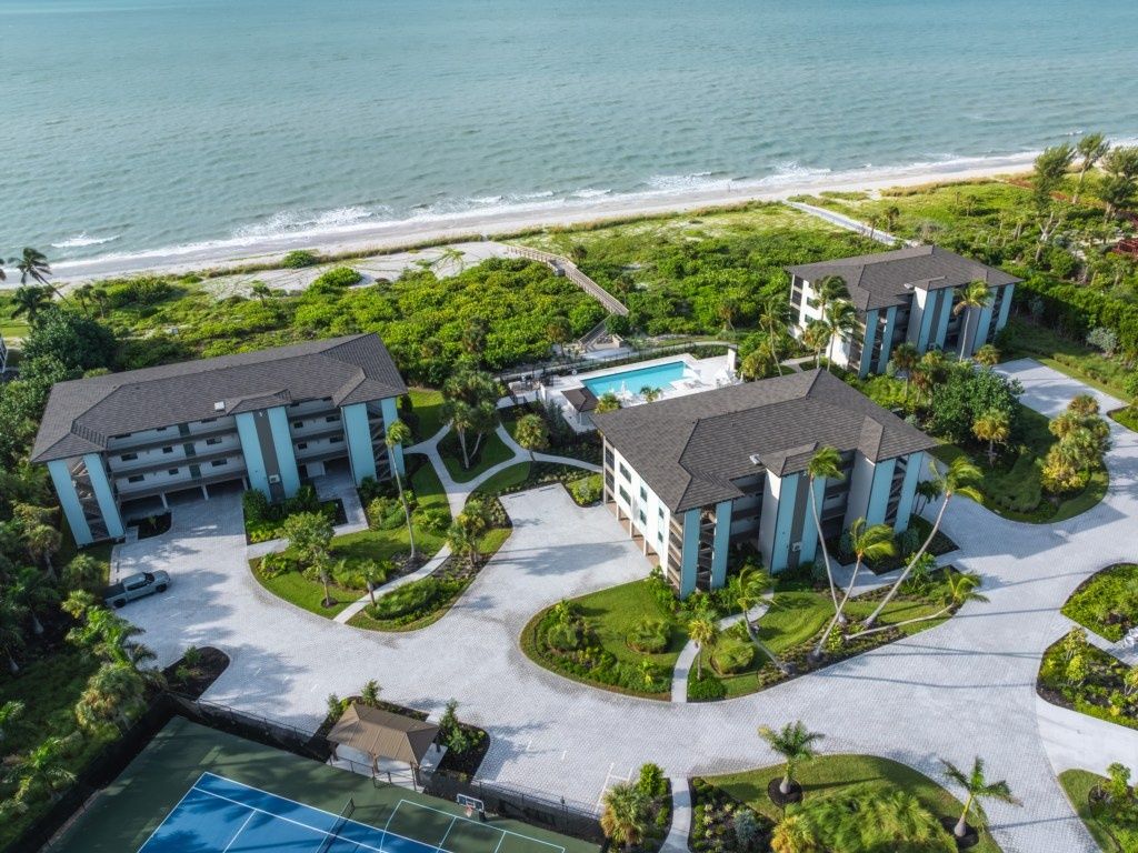 A resort with multiple buildings, a swimming pool, and a tennis court.