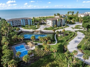 Un resort con diversi edifici, una zona piscina e vista sull'oceano.