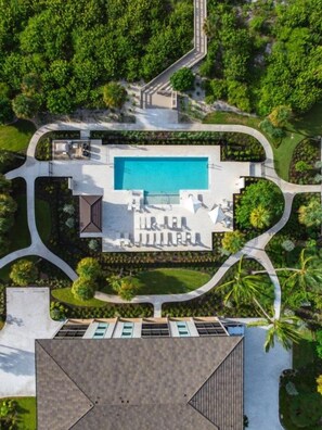 Luchtbeeld van een resort met een zwembad, een loungeruimte en aangelegde tuinen.