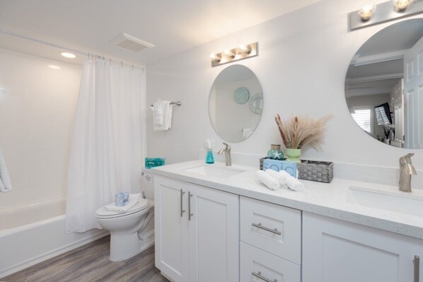 A bathroom with a white sink, mirror, and vanity. - Pelicans Roost 103 2 Bedroom Condo (Sanibel)