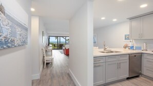 A modern kitchen with grey cabinets, a stainless steel sink, and a dishwasher. - Pelicans Roost 105 2 Bedroom Condo (Sanibel)