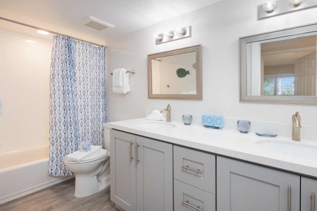 A bathroom with a white sink, a mirror, and a shower curtain.