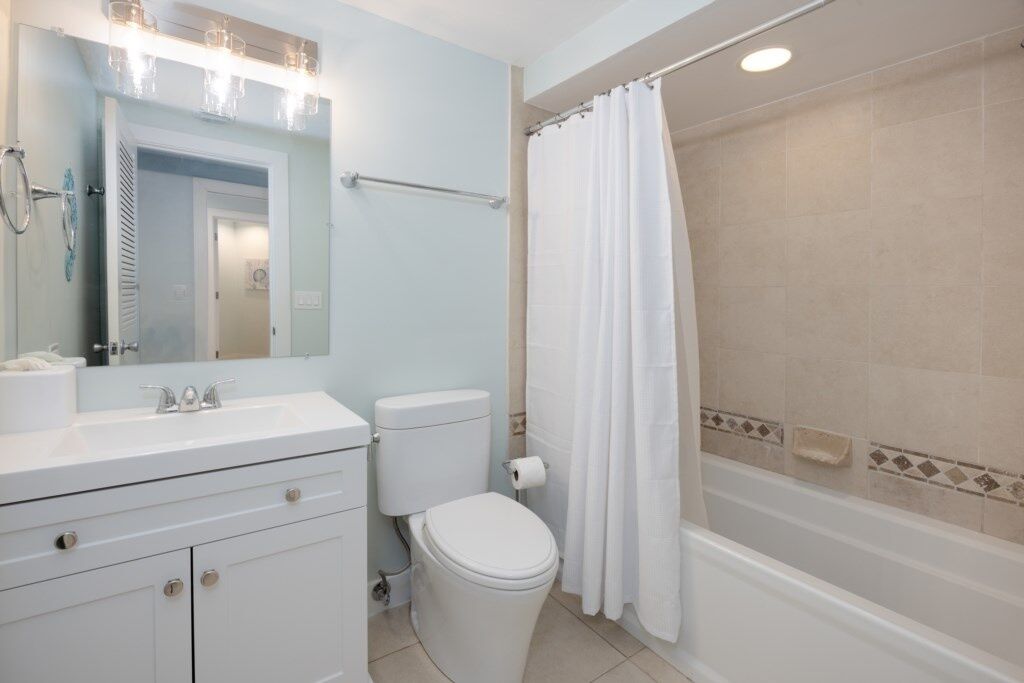 A bathroom with a white sink, toilet, and bathtub.