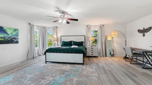 A bedroom with a bed, a desk, a chair, a ceiling fan, and a painting of the aurora borealis. - World Showcase At Windwood Bay By Shine Villas 5 Bedroom Villa (Davenport)