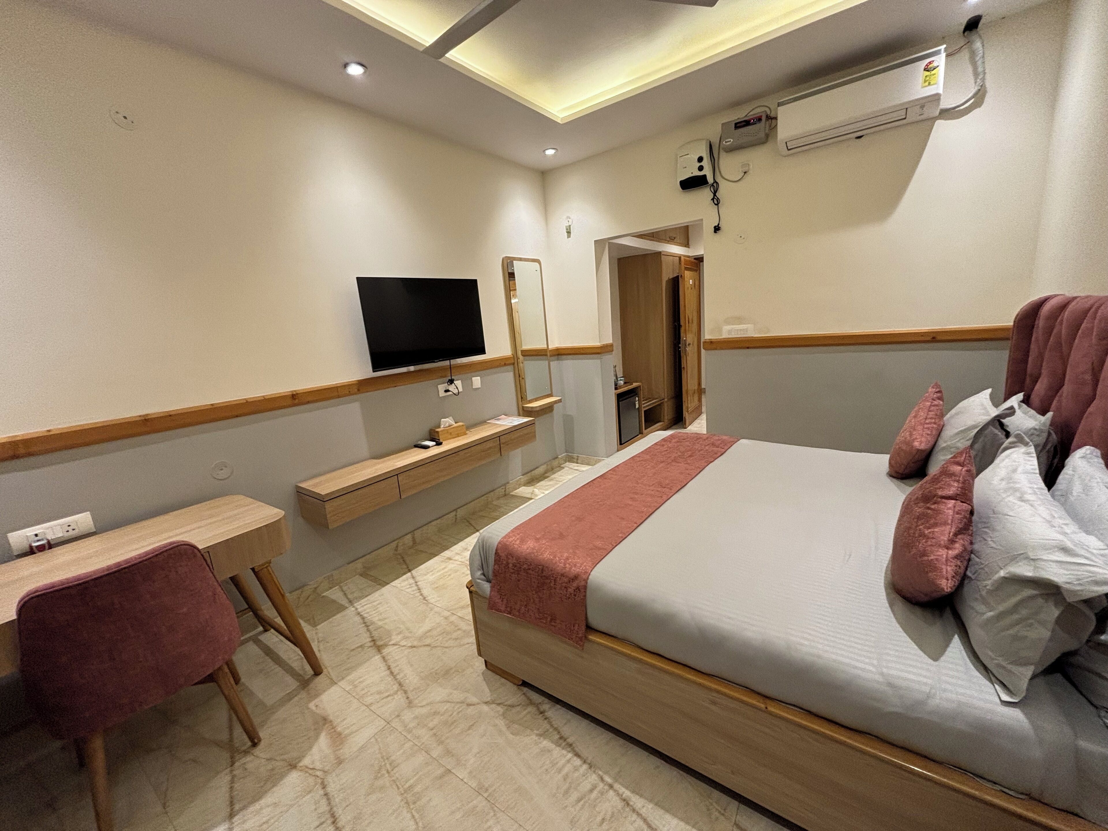 Une chambre d’hôtel équipée d’un lit, d’un bureau, d’une chaise, d’une télévision et d’un appareil de climatisation.