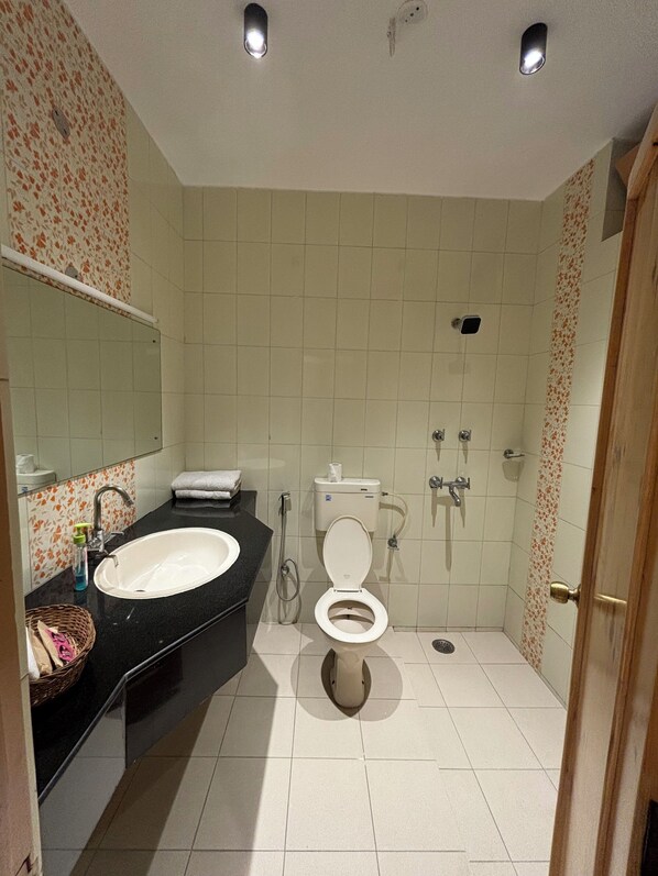Un baño con lavamanos amplio, inodoro y ducha.