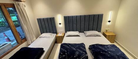 A double bed with a grey headboard and two bedside tables, each with a nightstand lamp.