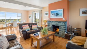 A spacious living room with a fireplace, a dining area with a view, and a cozy seating area.