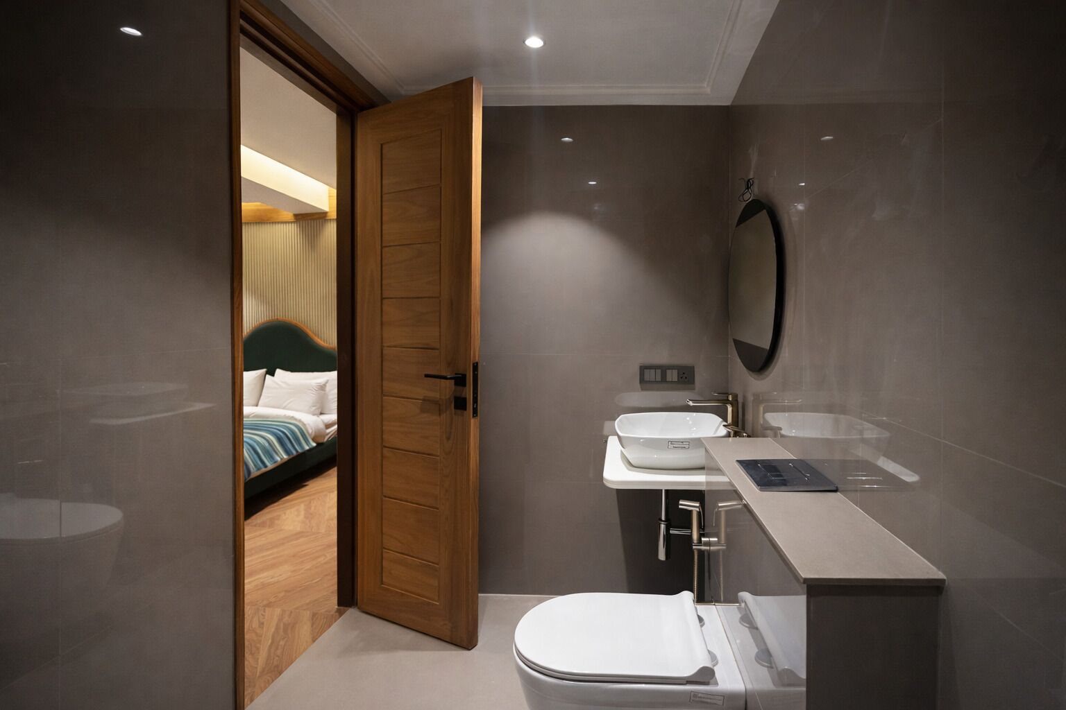 A modern bathroom with a toilet, sink, and mirror.