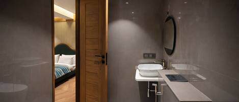 A modern bathroom with a toilet, sink, and mirror.