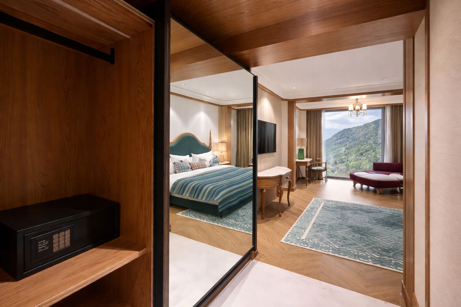 A hotel room with a bed, a desk, a chair, a sofa, and a view of the outdoors.