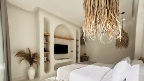 Un dormitorio moderno con una cama grande, estanterías empotradas, un televisor de pantalla plana y una l ámpara colgante.