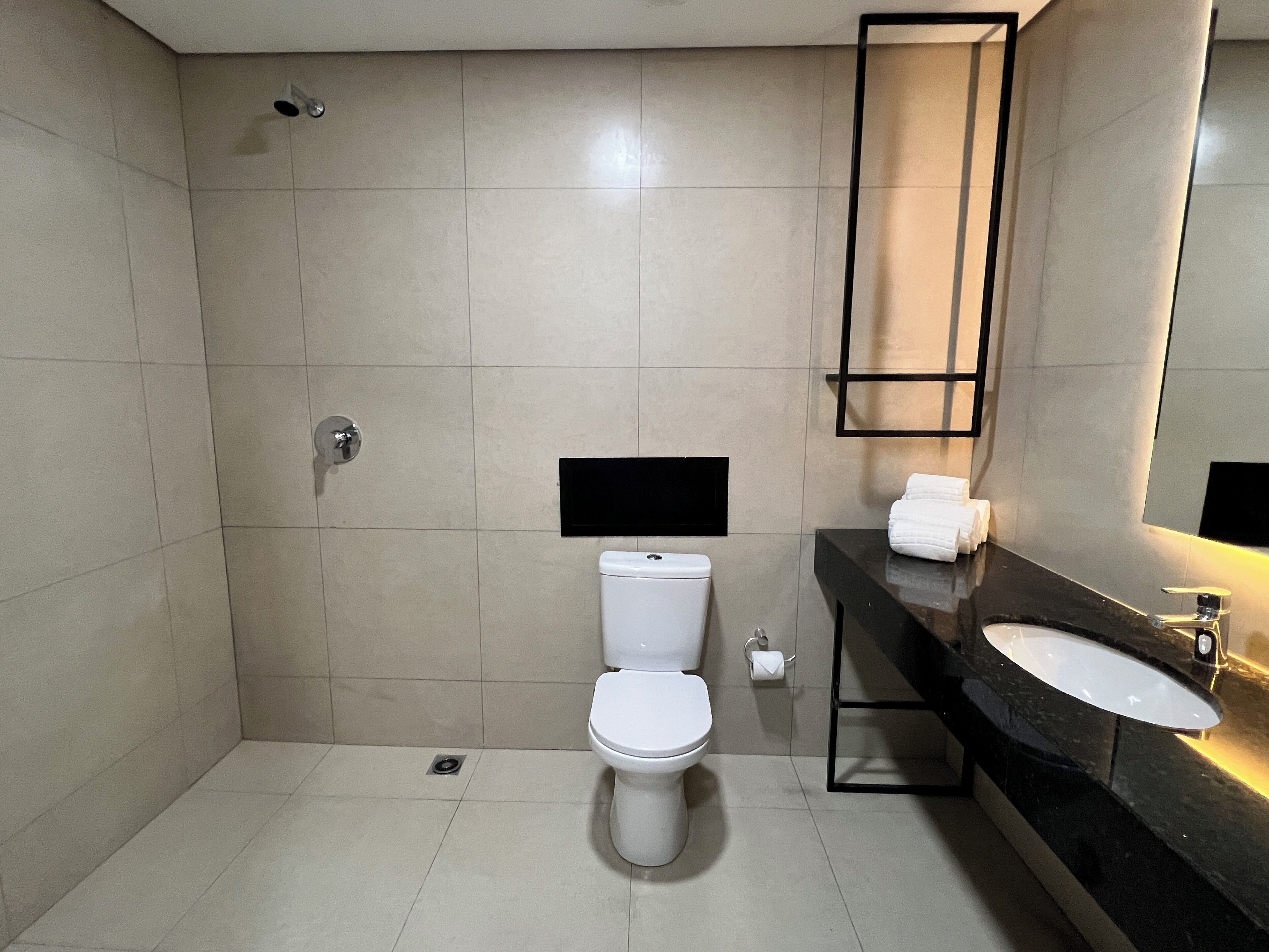 A modern bathroom with a toilet, sink, and shower.