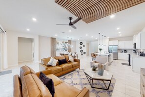 Relax in a spacious living area with a comfortable sofa and matching ottoman, complemented by a stylish coffee table.