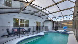 An indoor swimming pool with a glass ceiling, a sun dial, and a poolside seating area with chairs and a table. - World Showcase 5 Bedrooms at Windwood Bay (Davenport)