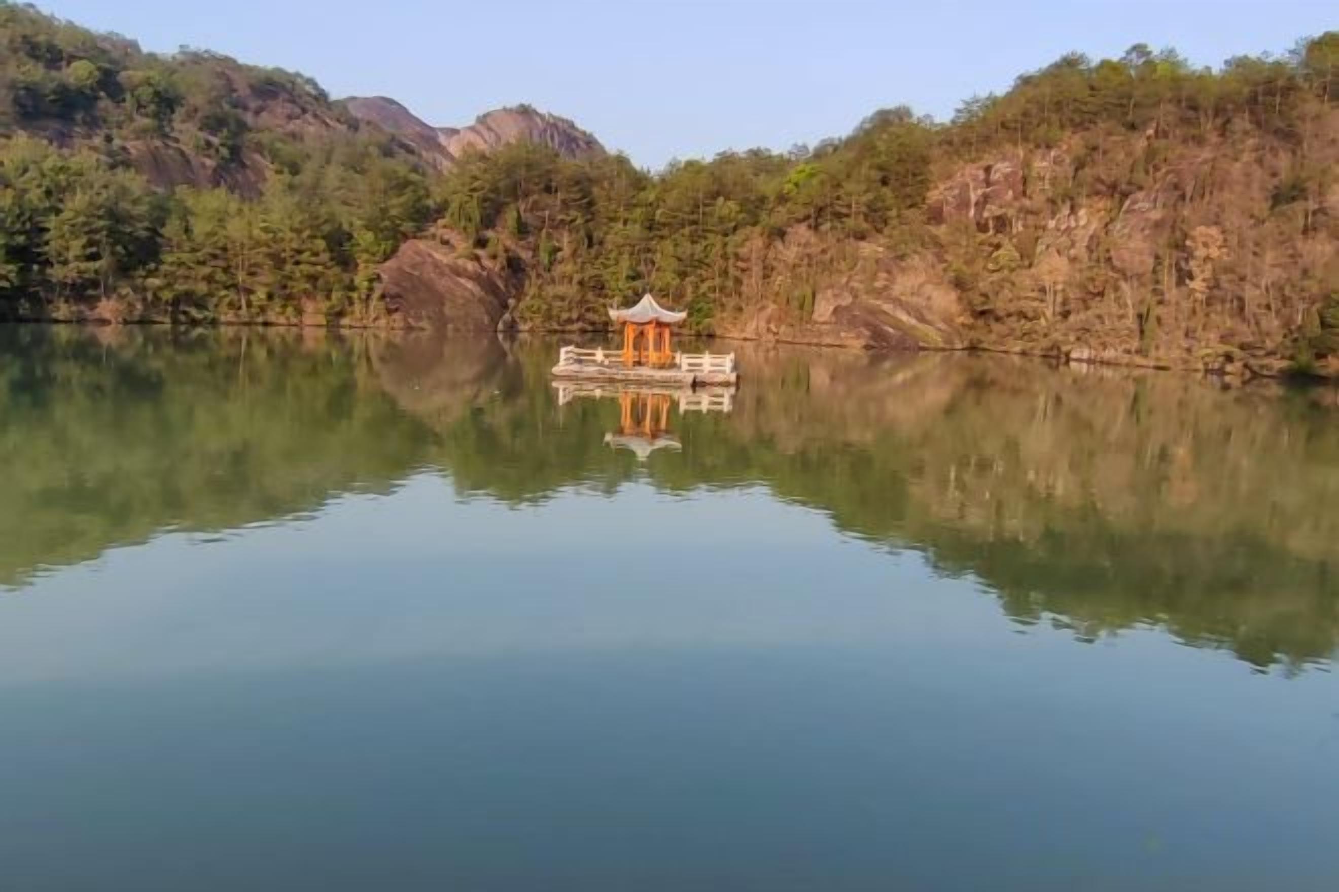 Un lac paisible, avec une jetée en bois et un pavillon.