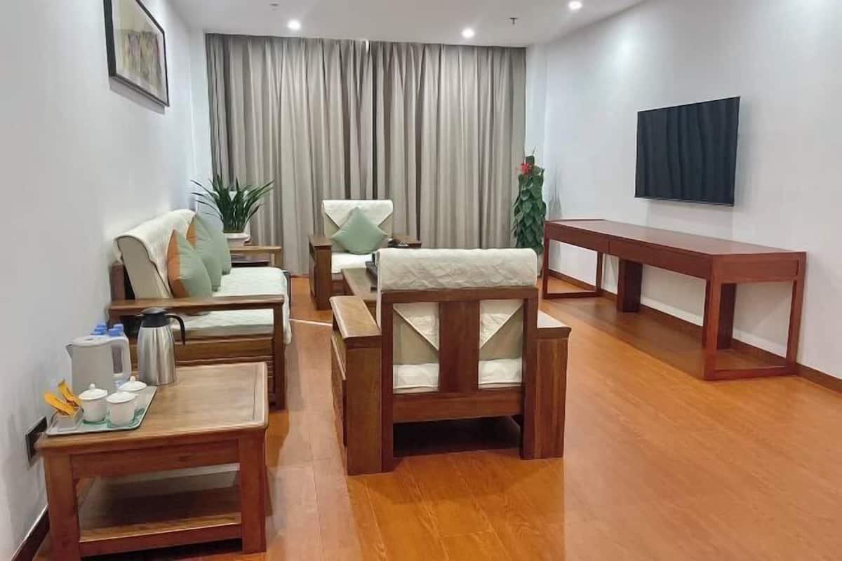 Un salon moderne comprenant un canapé, des fauteuils, une table basse, un téléviseur et une table à manger.
