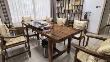 A dining area with a wooden table, chairs, and a bookshelf.