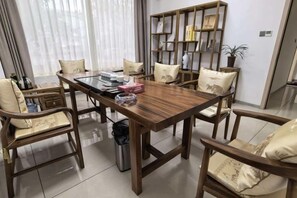 A dining area with a wooden table, chairs, and a bookshelf.