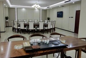 Un comedor con una mesa larga, varias sillas y una araña.