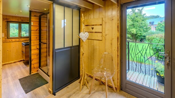 A wooden interior with a sliding door leading to a balcony.