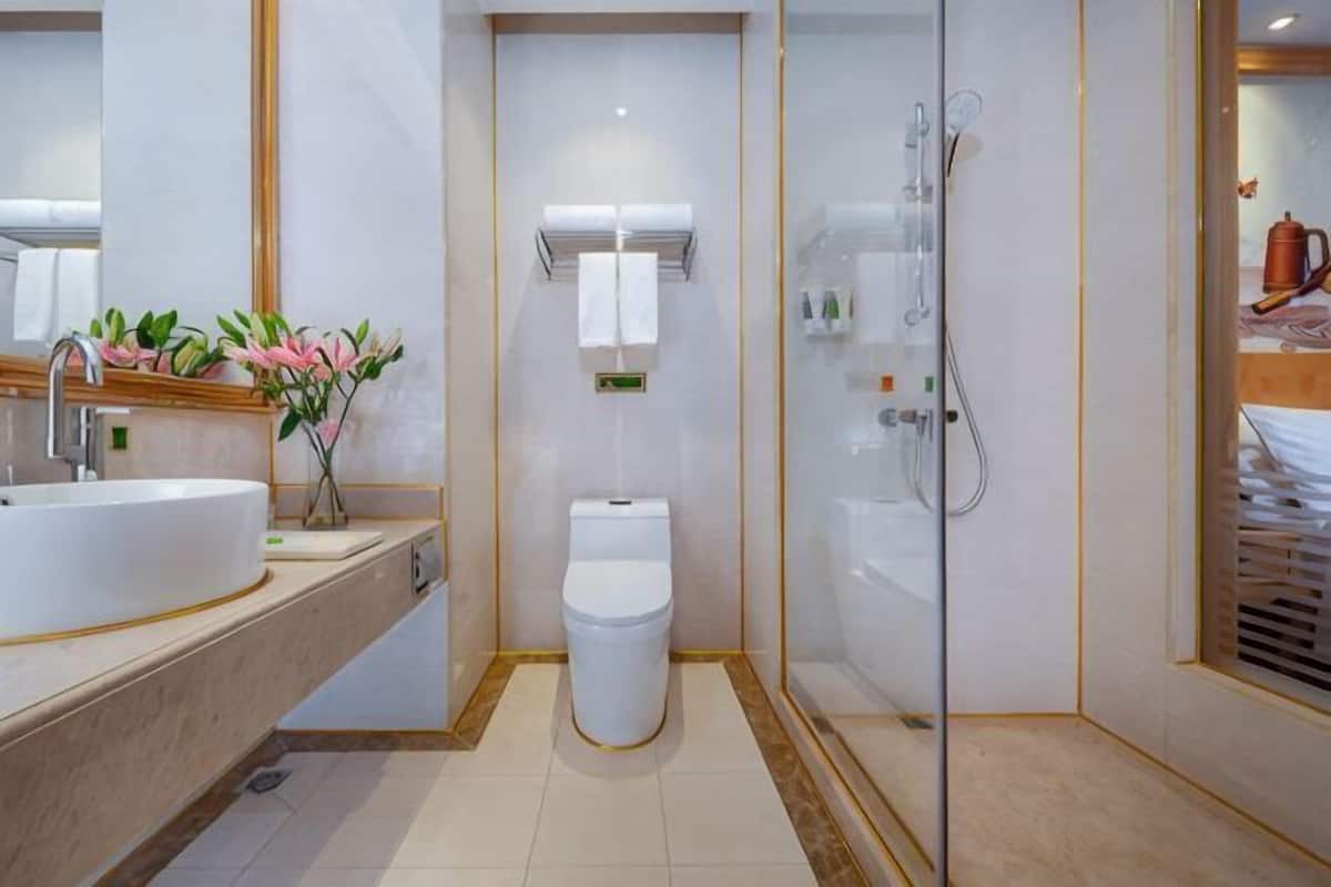 Um banheiro moderno com uma pia grande, vaso sanitário e chuveiro com divisória de vidro.