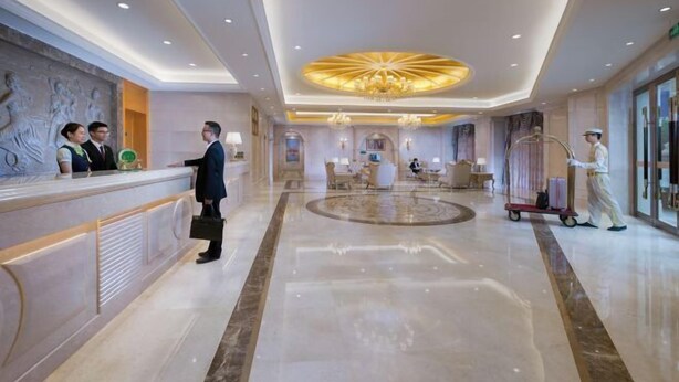A spacious lobby with a reception desk, a chandelier, and a clean, polished floor. - Vienna International Hotel (Zijin)