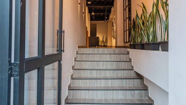 Una escalera de madera con un diseño moderno que conduce a un piso superior.
