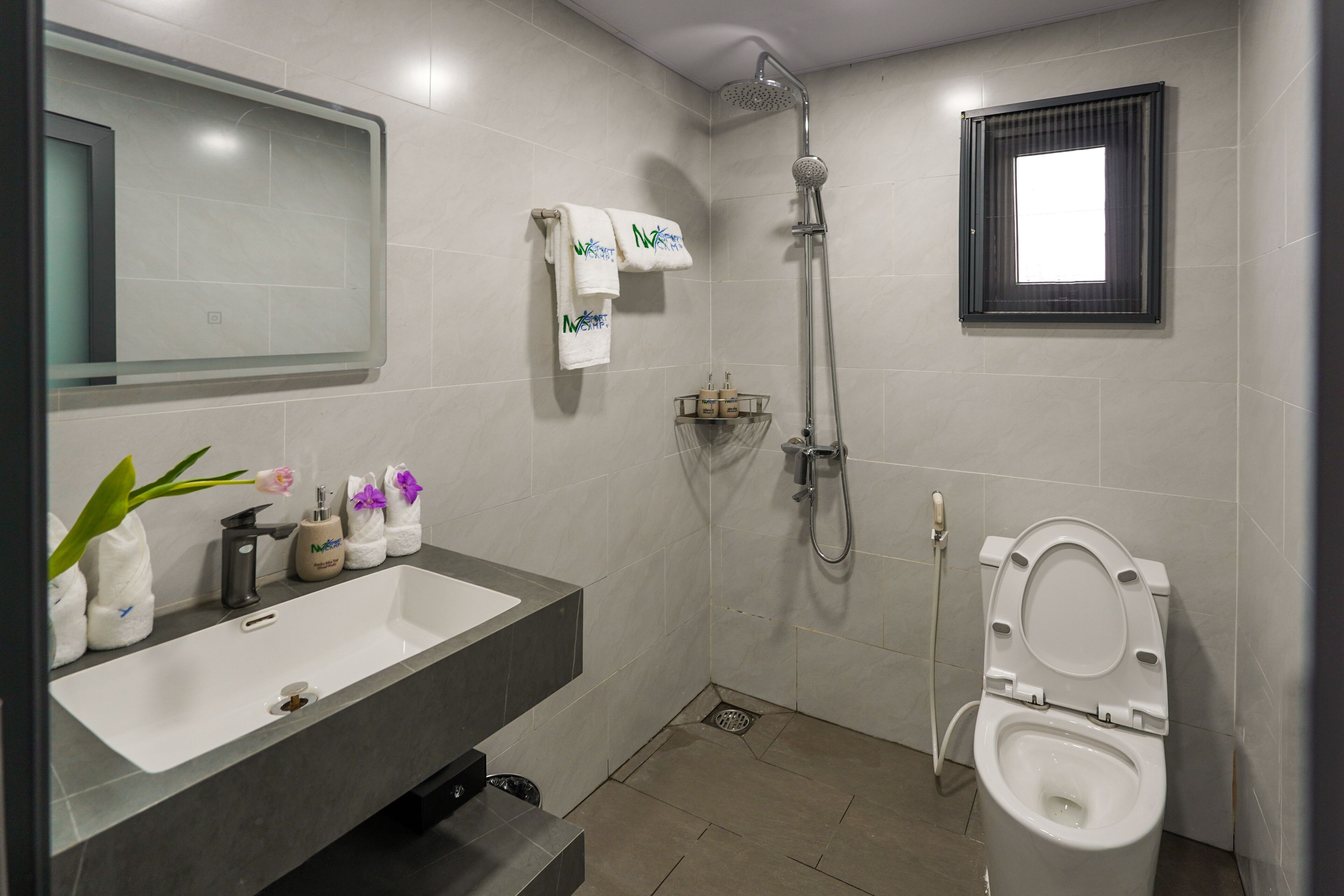 Ein modernes Badezimmer mit einem großen Waschbecken, Toilette und Dusche.