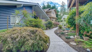 Un quartiere residenziale con un vialetto che conduce a delle case, circondato da vegetazione e un piccolo giardino.