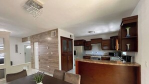 A modern kitchen with wooden cabinets, a granite countertop, and a built-in island. - House in the Consulate! (Chihuahua)