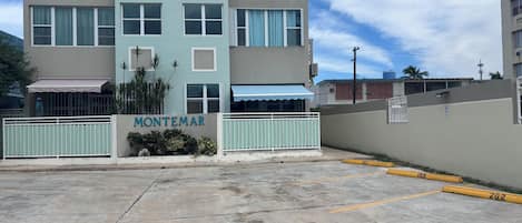 A multi-story building with a sign reading "MONTEMAR" and a gated entrance.