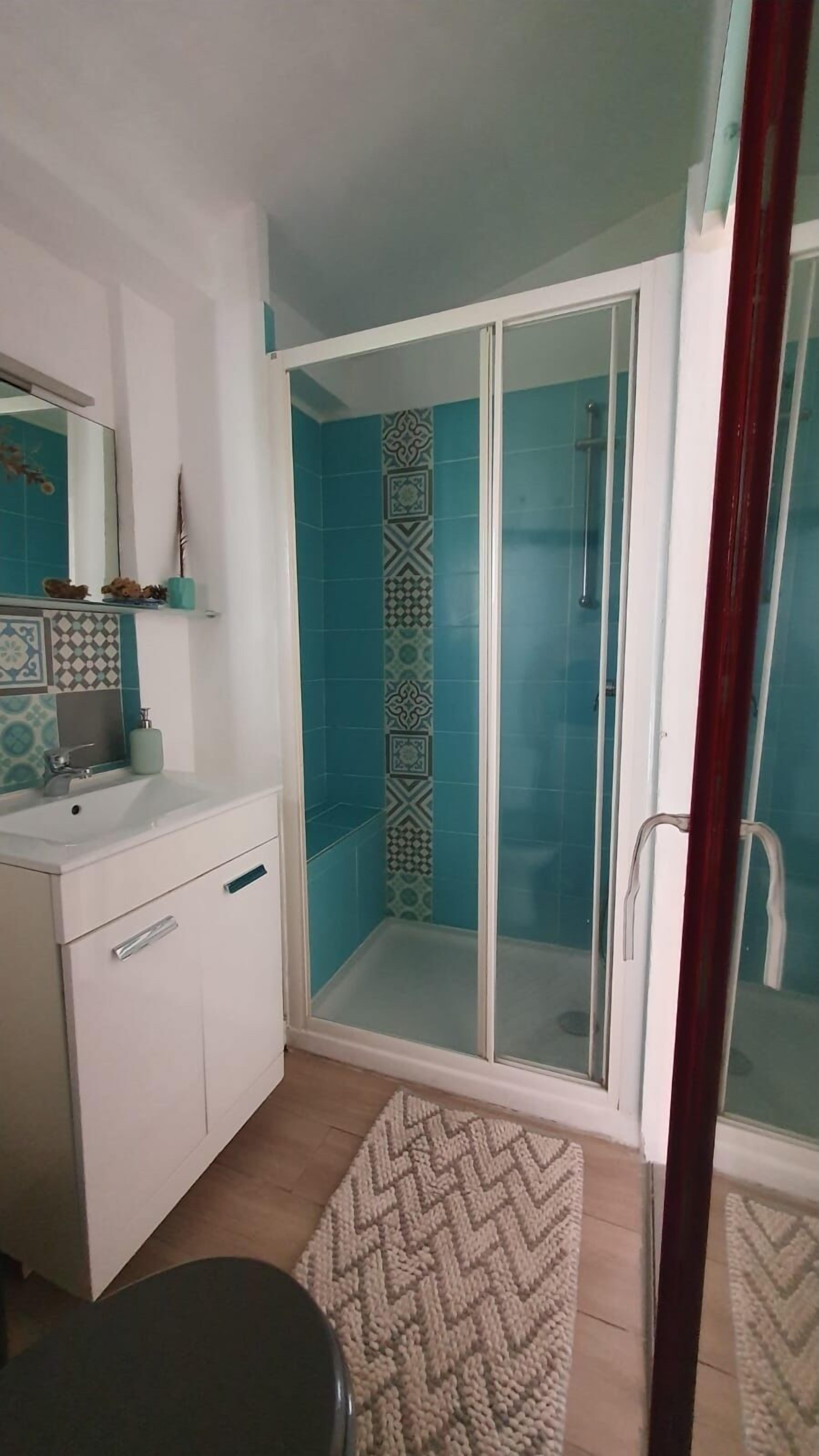 Een douche, handdoeken, zeep, shampoo