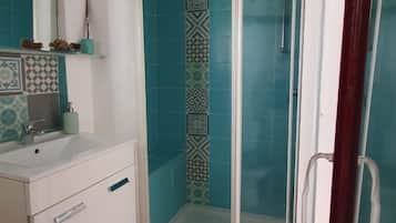 Een douche, handdoeken, zeep, shampoo