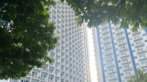 A residential building with a swimming pool, surrounded by greenery and a lifebuoy.