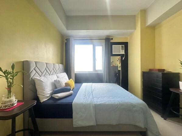 A bedroom with a bed, a dresser, a desk, and a window with curtains. - SMDC Jazz Residences Makati 30th (Makati)