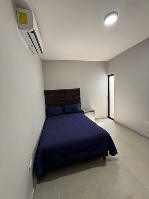 A bedroom with a bed, a nightstand, an air conditioning unit, and a ceiling light. - Casa Area Consulate! (Ciudad Juarez)