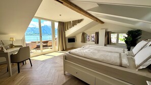 Ein Schlafzimmer mit einem großen Bett, einem Schreibtisch, einem Stuhl und einem Fernseher.