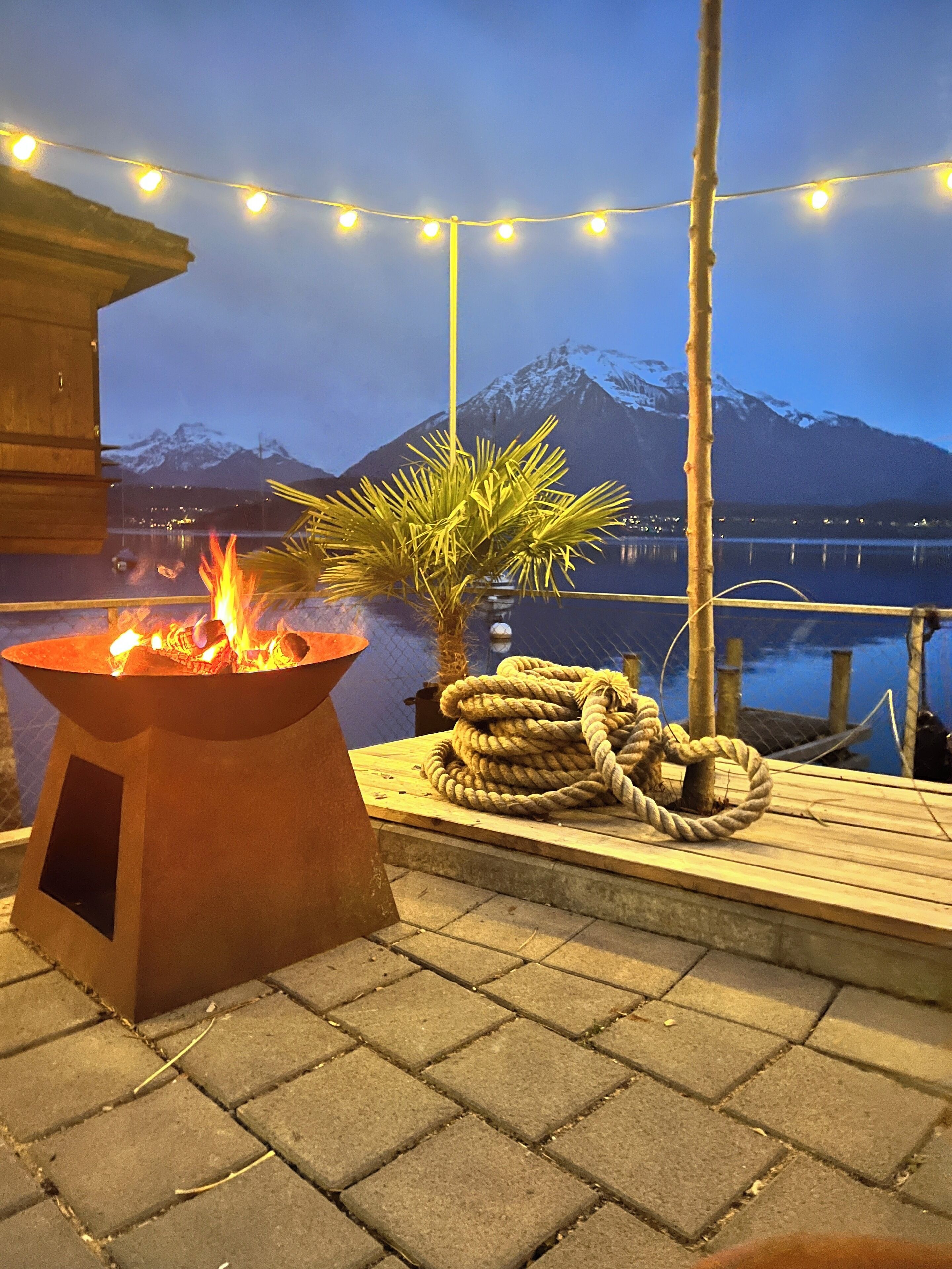 A fire pit with a view of a mountain and a body of water.