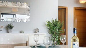 A dining area with a table set for two, a bottle of wine, and a potted plant. - Green Blue Horizon by Atlantic Holiday (São Vicente)