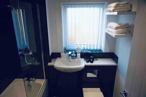 Een haardroger, handdoeken, zeep, toiletpapier